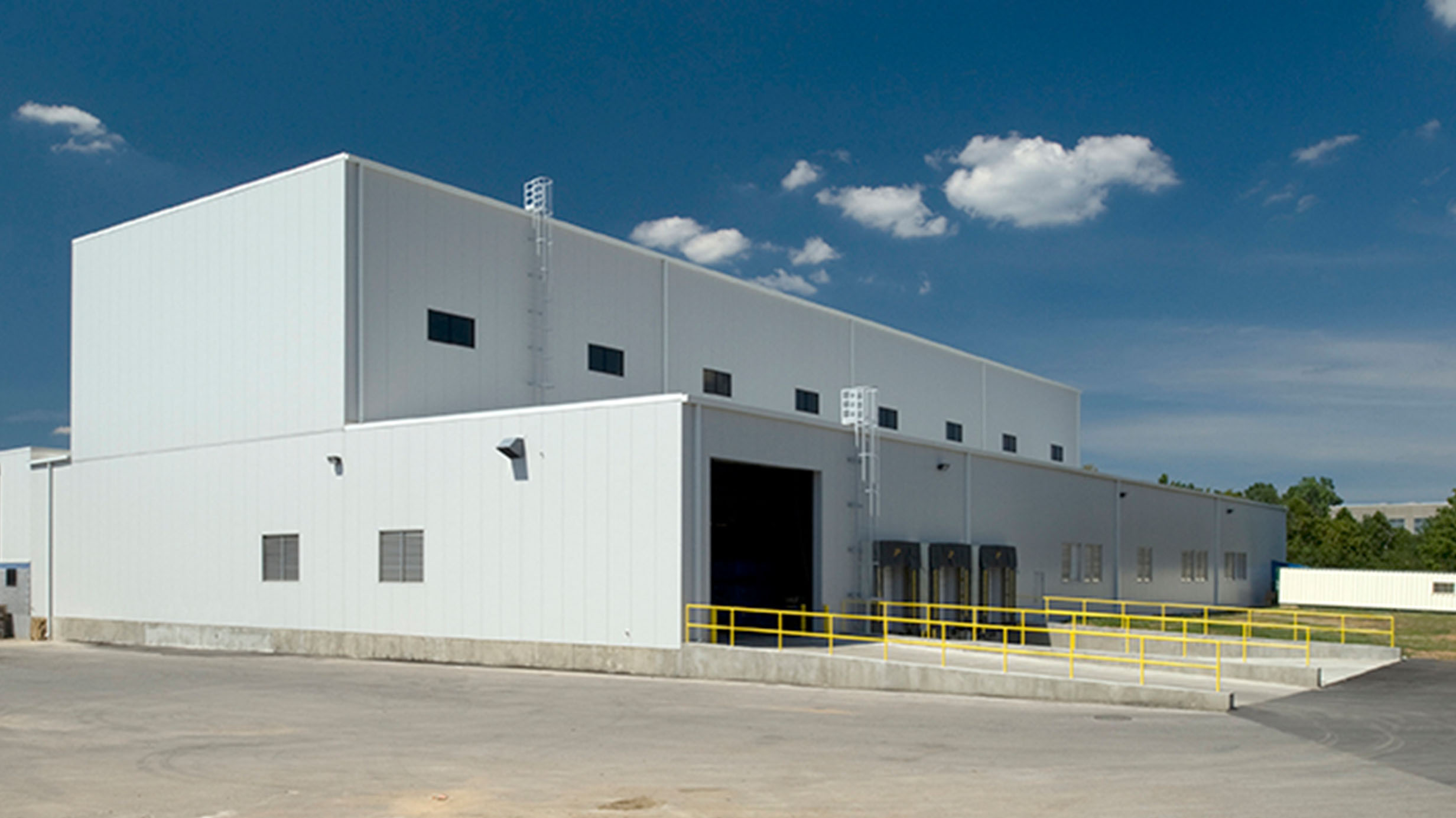 A modern white manufacturing plant on a sunny day