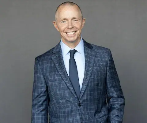 Professional portrait of Micheal Rankin smiling in a suit