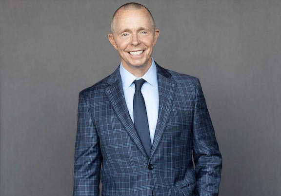 Professional portrait of Micheal Rankin smiling in a suit