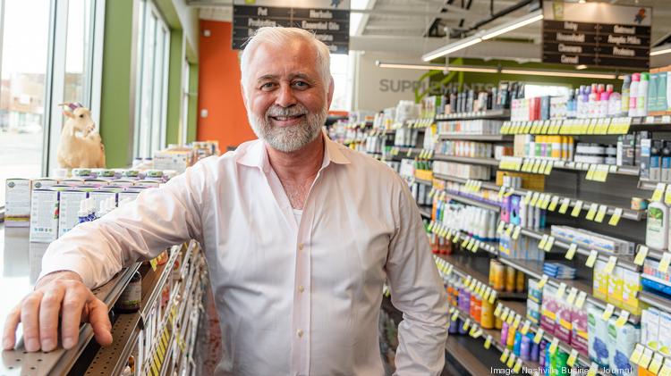 A white-haired man smiling in a local grocery store.