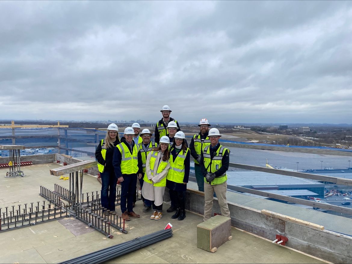 the Crain Construction team on the rooftop of the BNA Hilton with hardhats on a cloudy day