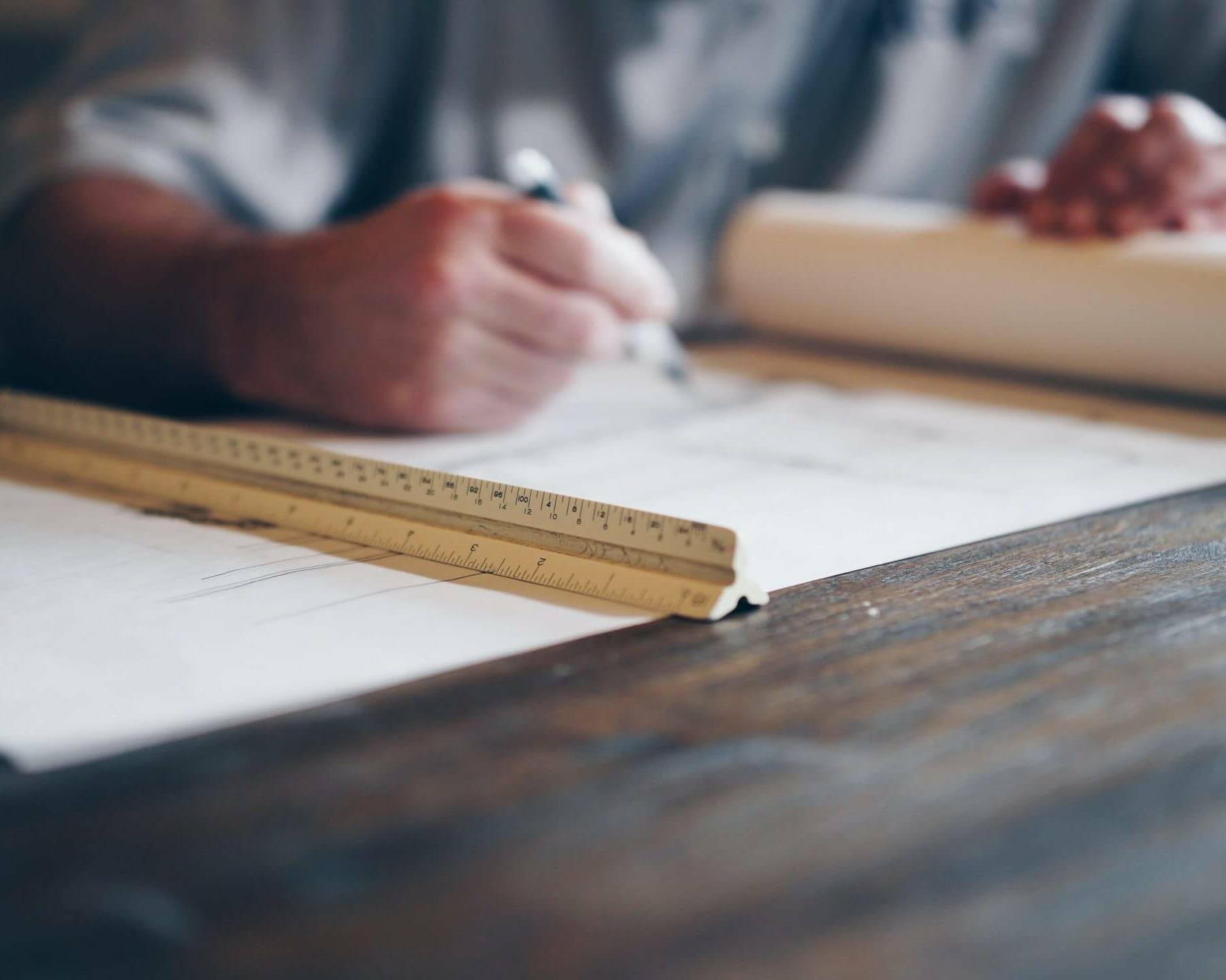 man looking at construction plans on a wood table