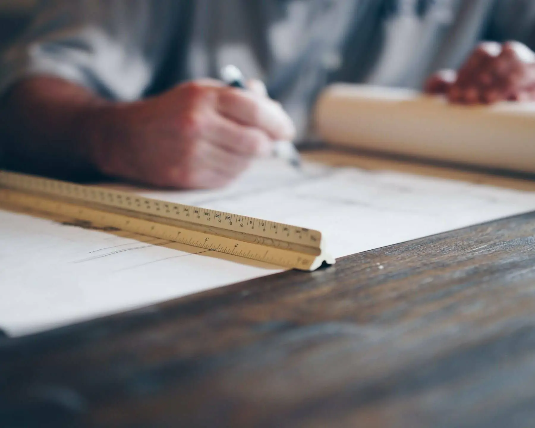 man looking at construction plans on a wood table