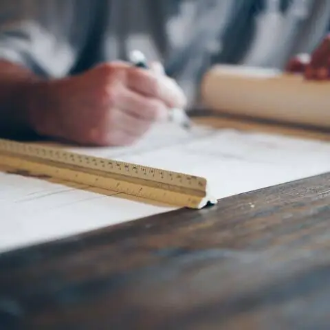 man looking at construction plans on a wood table