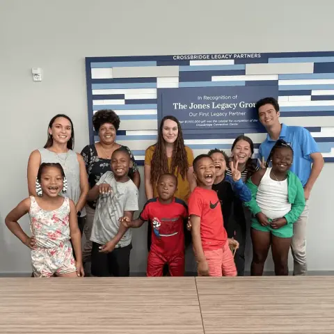 group of people standing in front of a sign