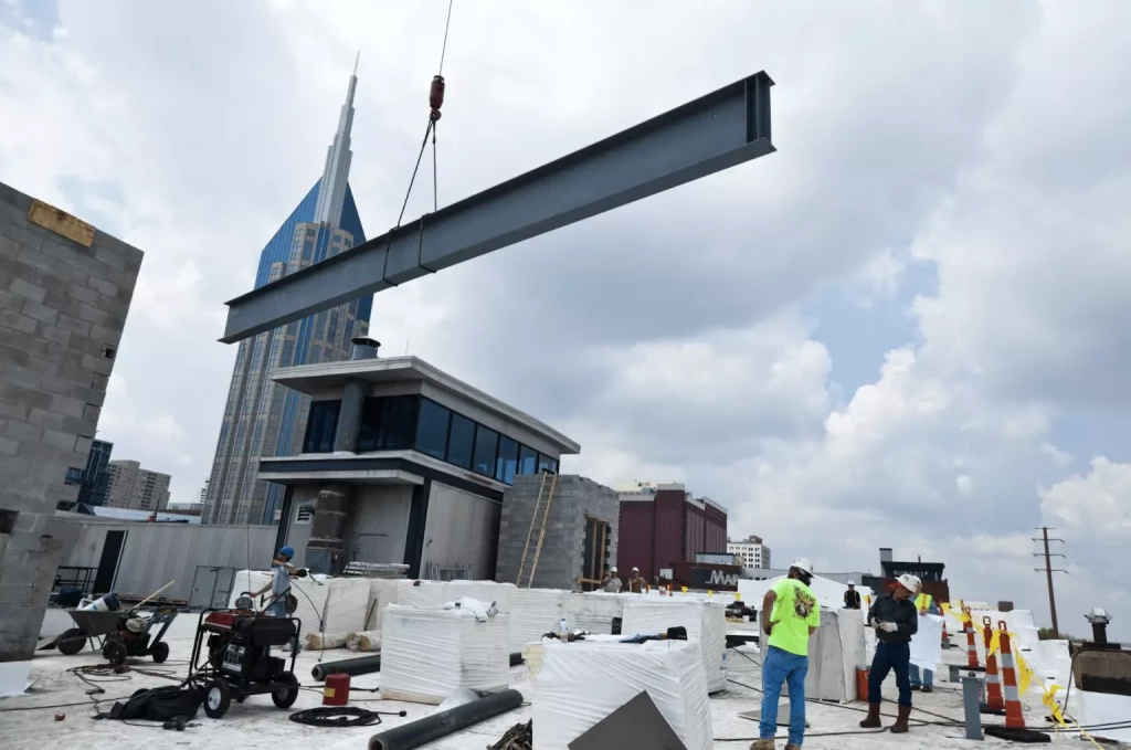concrete beam hanging from a crane on commercial construction site