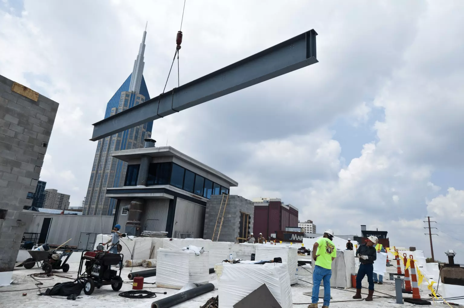 concrete beam hanging from a crane on commercial construction site