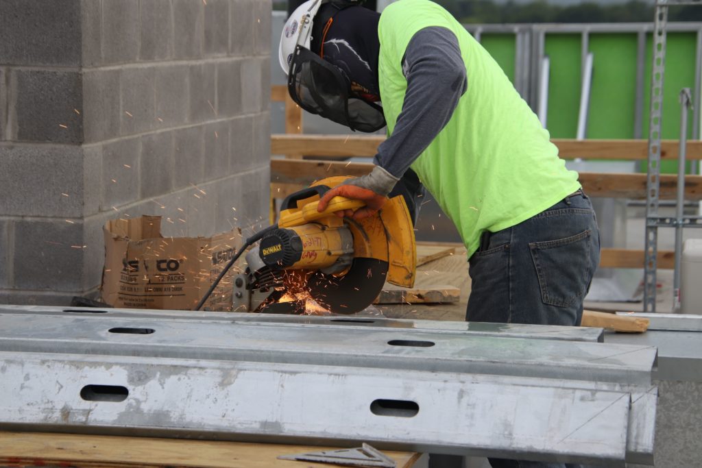 construction worker in safety gear using a table saw