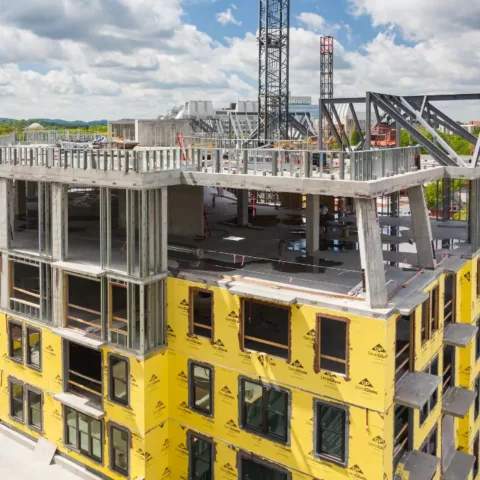 Building under construction with yellow house wrap