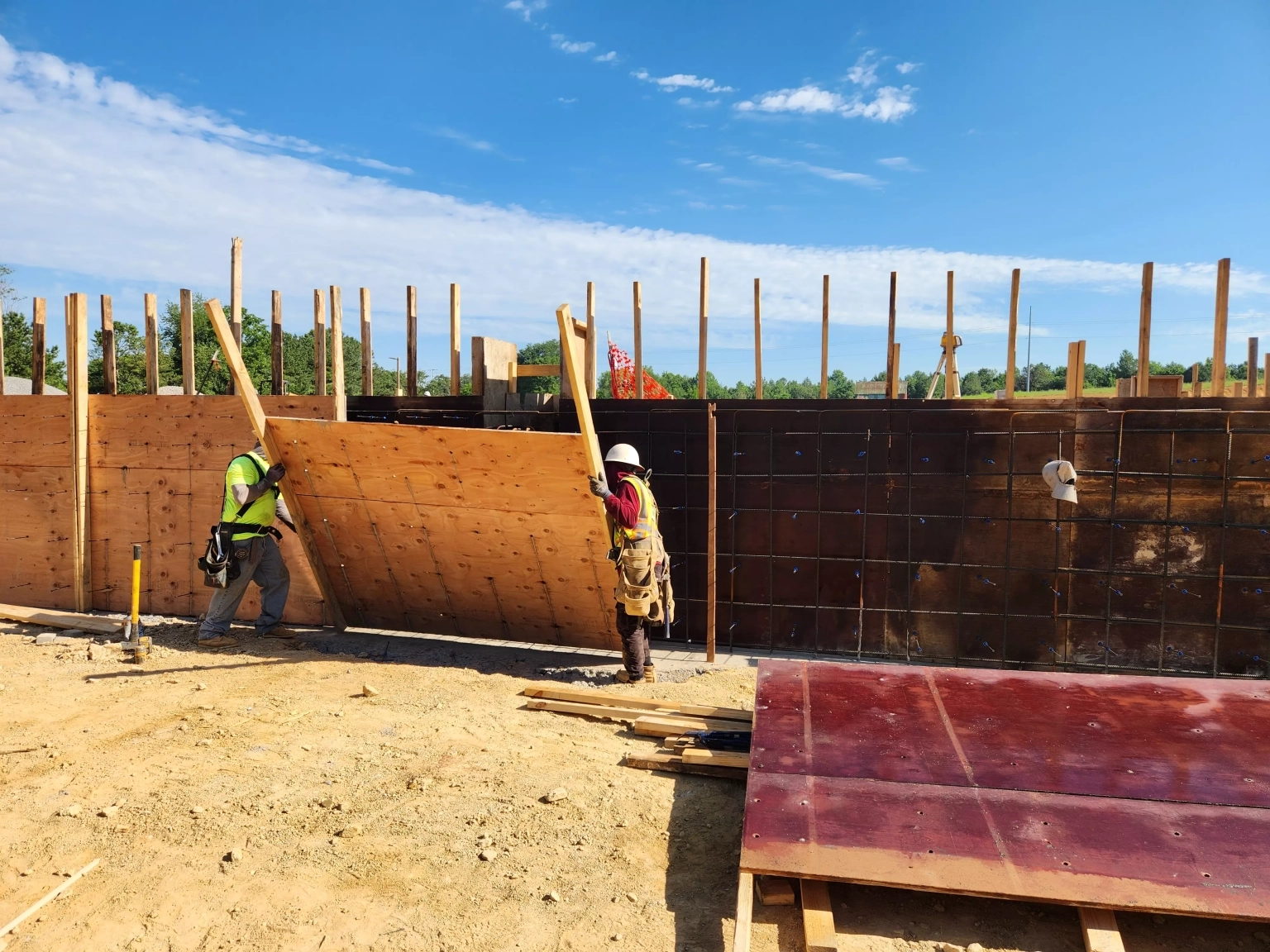two construction workers putting up a wooden wall