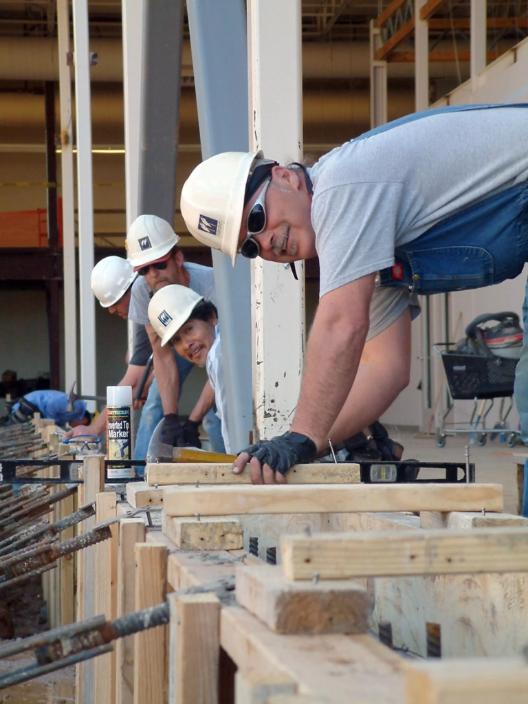 construction workers in hard hats working on a building project