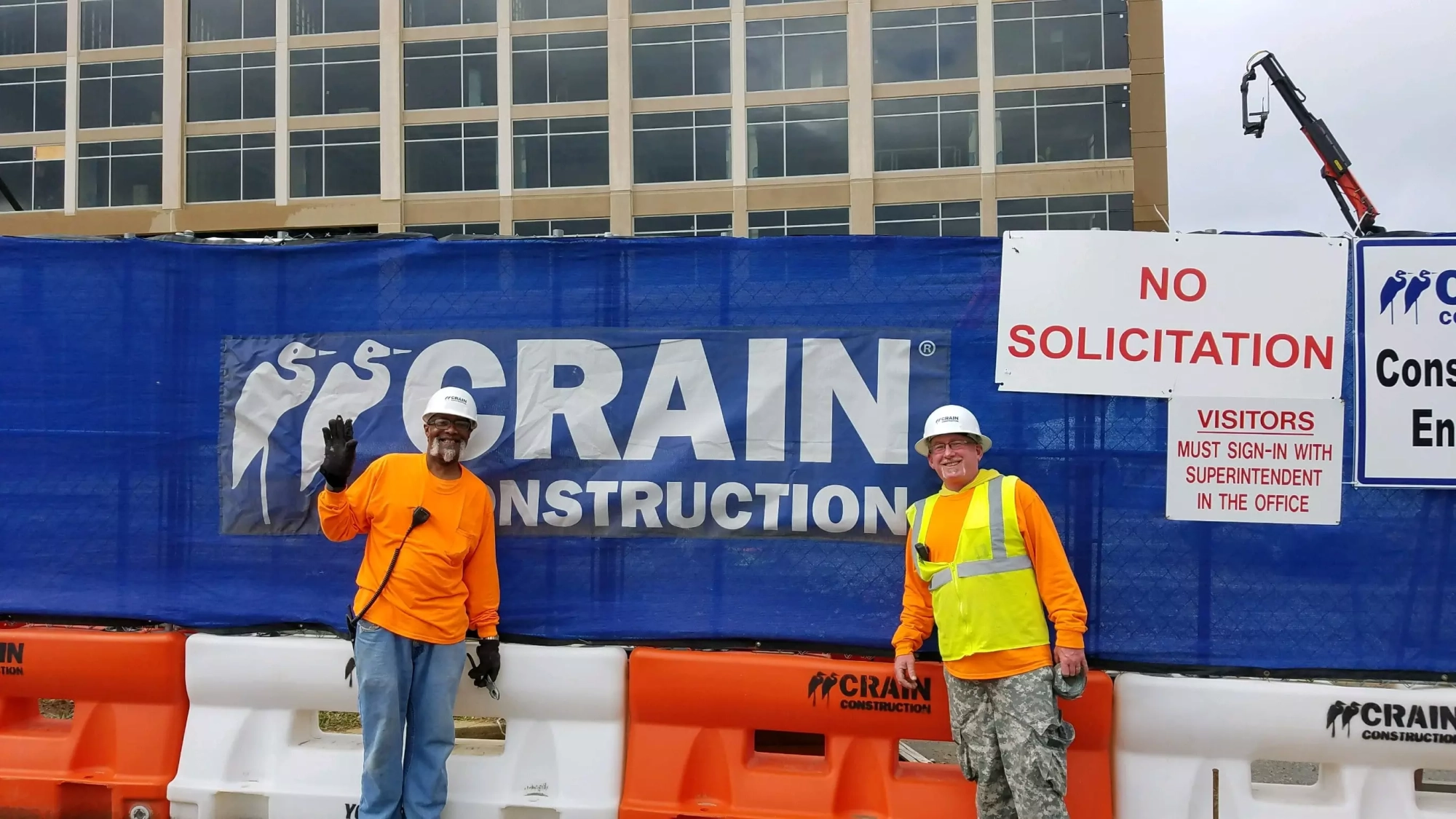 two construction workers posing in front of commercial construction project