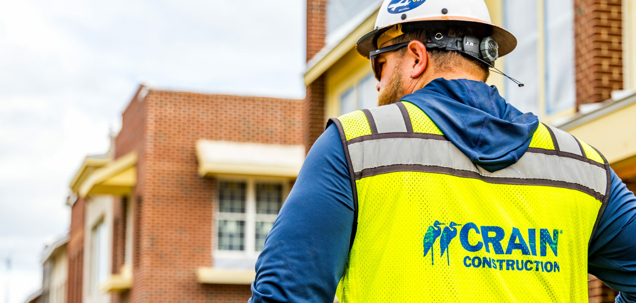 worker in crain construction safety vest on project site
