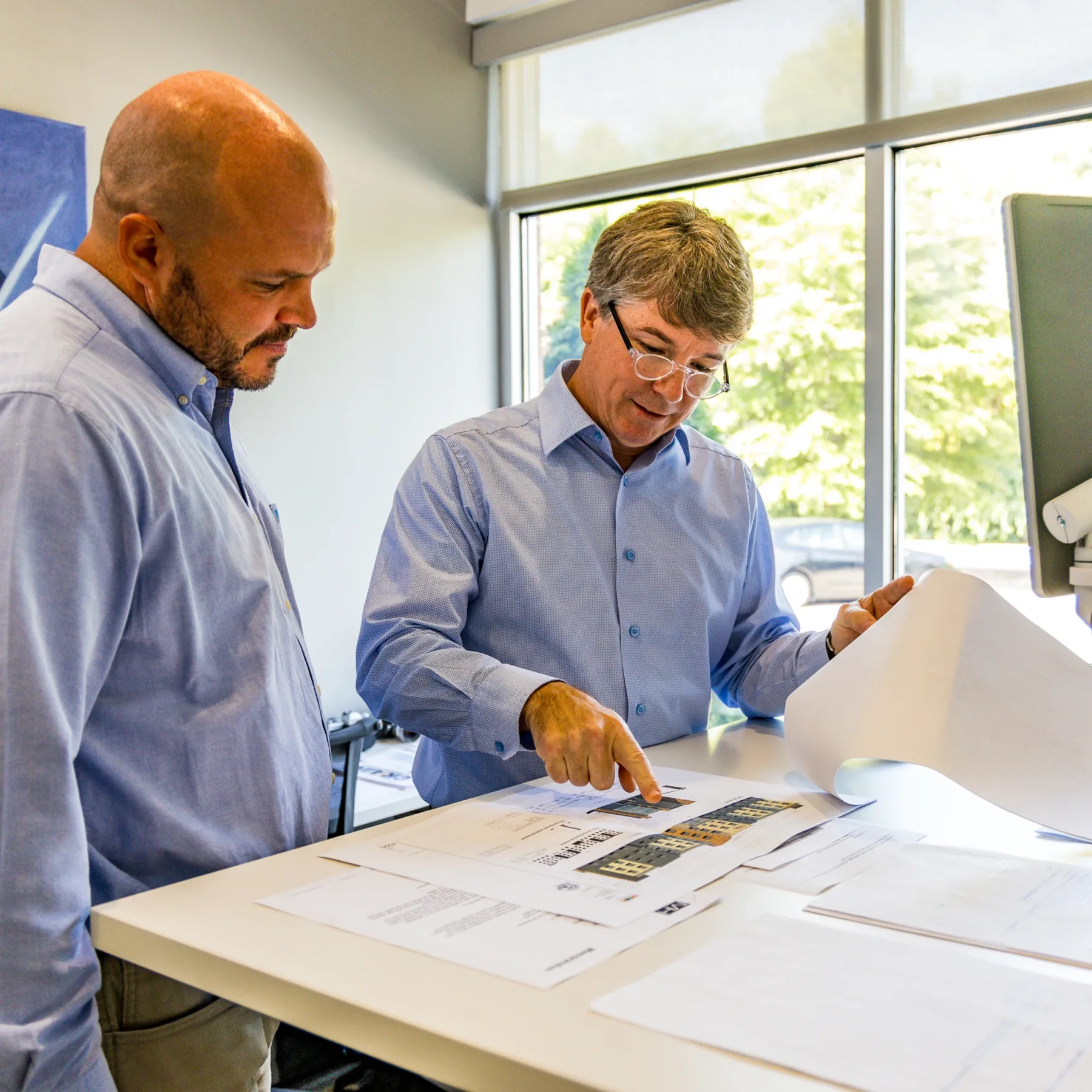 crain construction employees reviewing plans in office
