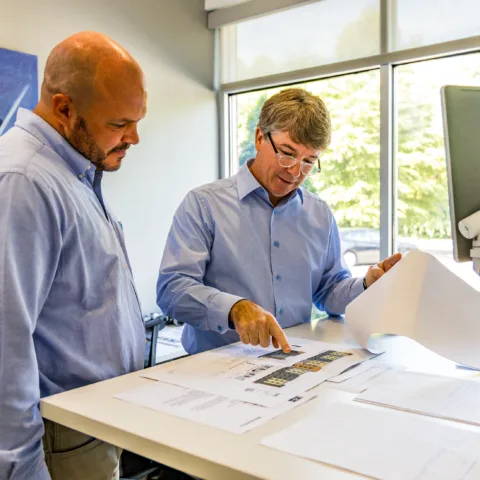 crain construction employees reviewing plans in office