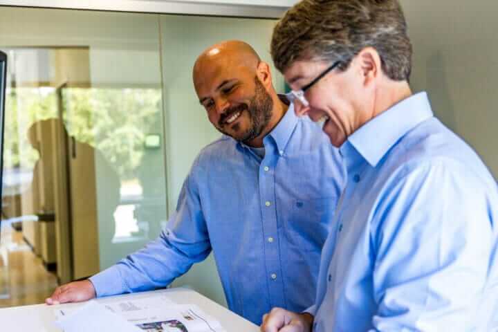 two crain construction employees discussing project in office