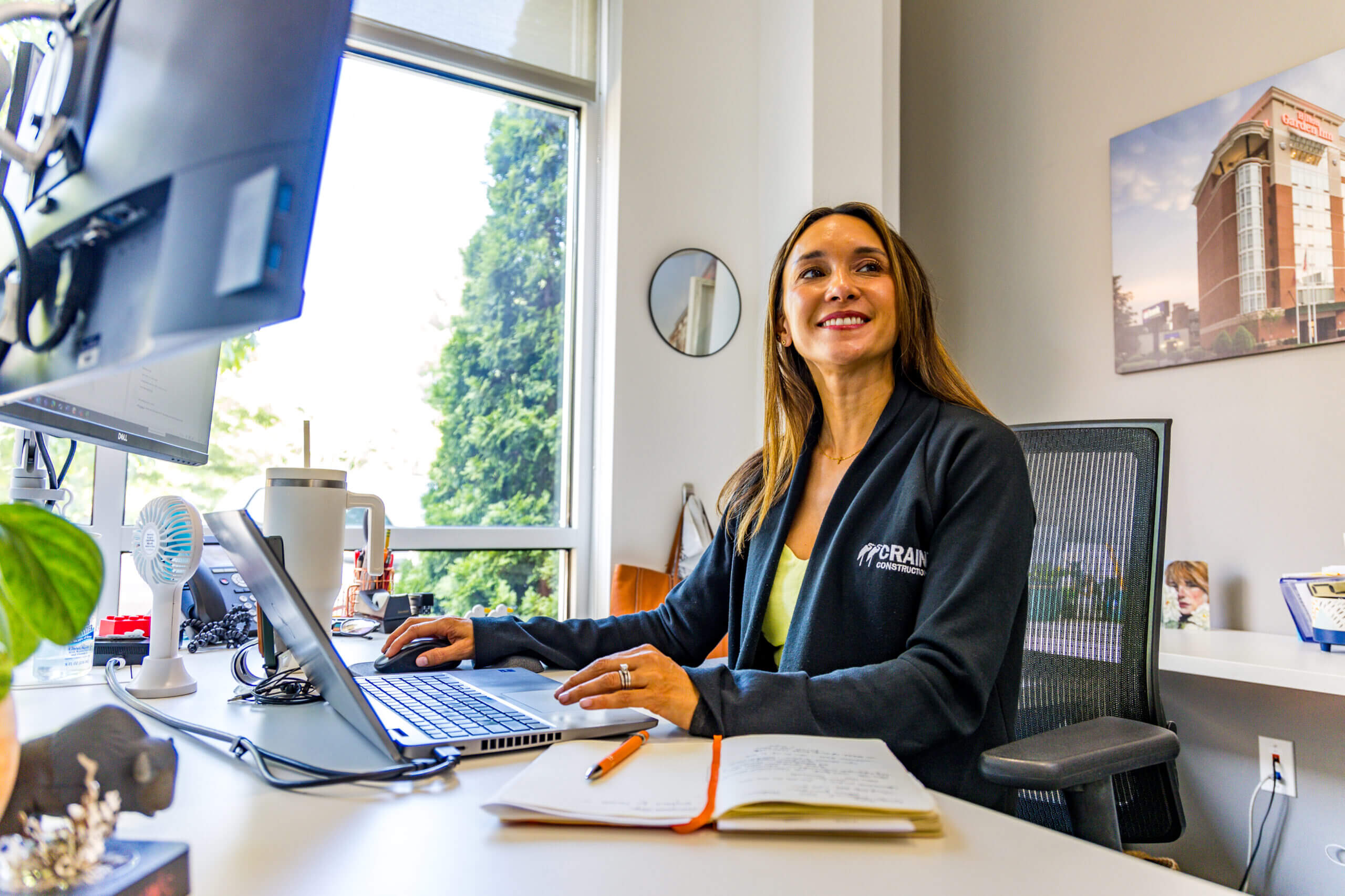 Crain Construction employee at office desk with window