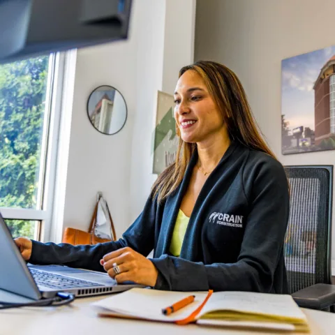crain construction employee at her office desk